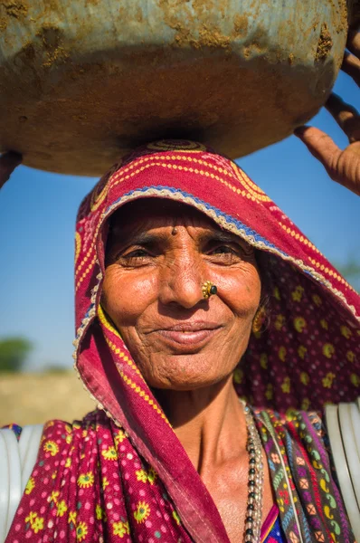 Rabari tribeswoman stands in field — Stock fotografie