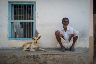 Indian man and dog sit