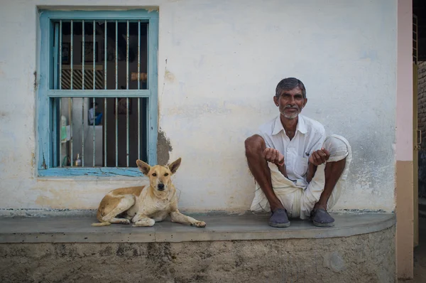 Indian man and dog sit — 스톡 사진