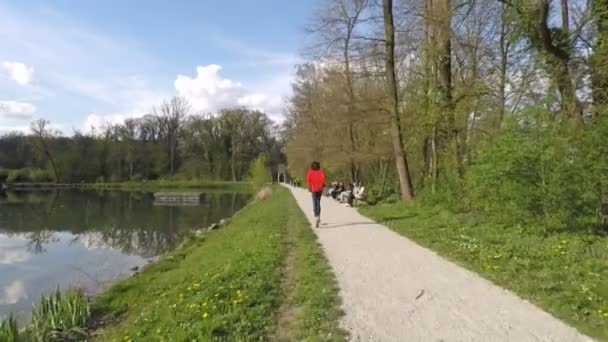 Pohled zezadu na člověka běží u jezera. — Stock video