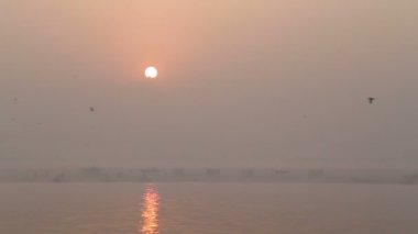Güneş puslu Ganj Nehri üzerinde