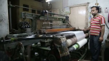 Adam çalışan bir makine dokuma tarafından standları