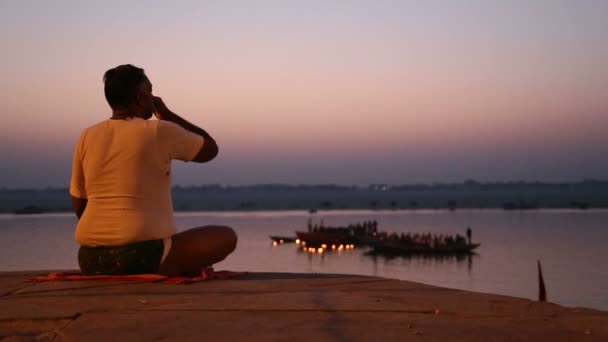 L'homme prie, les bateaux naviguent à la rivière Ganges . — Video
