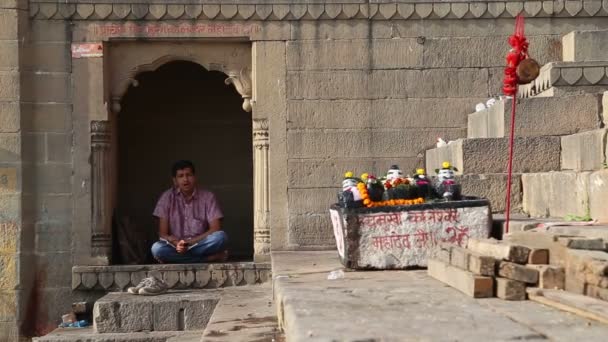 Человек молится во дворе храма — стоковое видео