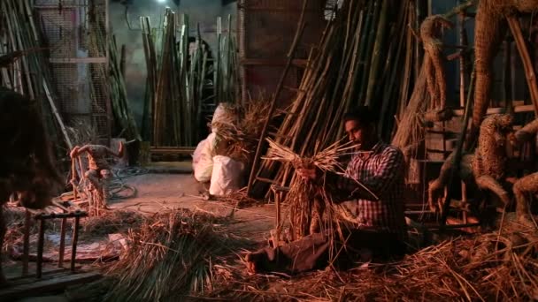 Man vormgeven van een formulier met behulp van stro in werkplaats in Varanasi. — Stockvideo