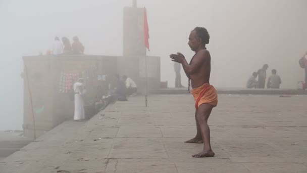 Человек, практикующий йогу на берегу Ганга — стоковое видео