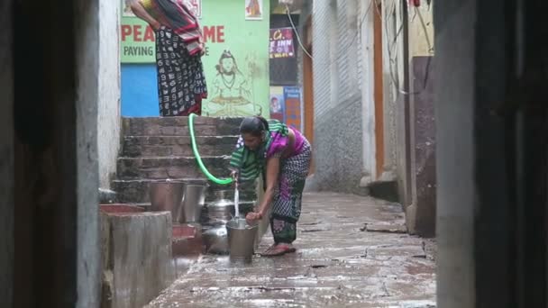 Mujer llenando un cubo con agua — Vídeo de stock