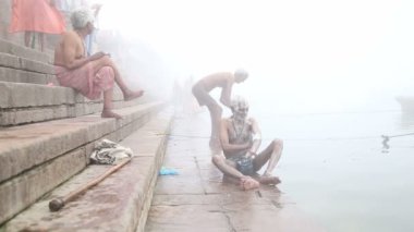 Varanasi sisli Ganj Nehri kıyısında onun vücut ovma adam.