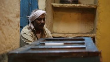 Atölyede oturan Hint adam