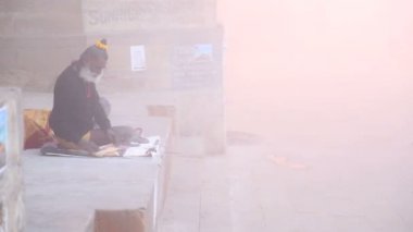 Ganj Nehri sisli, oturan adam yerleştir