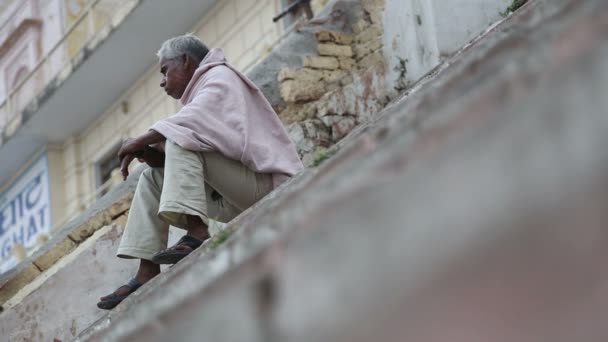 Hombre sentado en ghats — Vídeo de stock