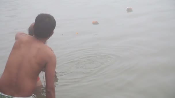 Mannen bidden en baden in de rivier de Ganges — Stockvideo