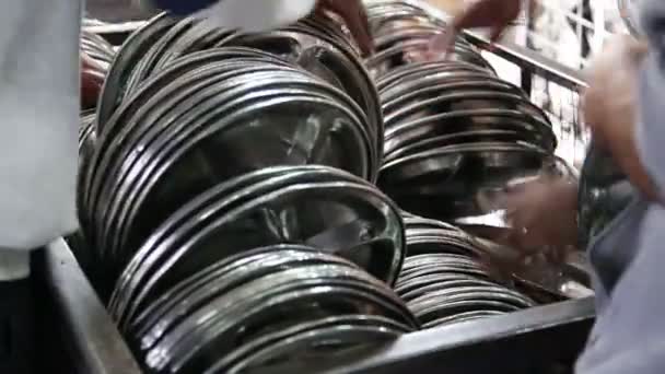 People arranging pile of silver plates — Stock Video