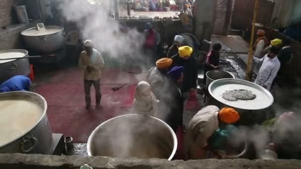 Lokale mensen bereiden van voedsel in grote ketels in openbare keuken in Amritsar. — Stockvideo