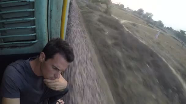 Hombre sentado junto a la entrada del tren abierto — Vídeo de stock