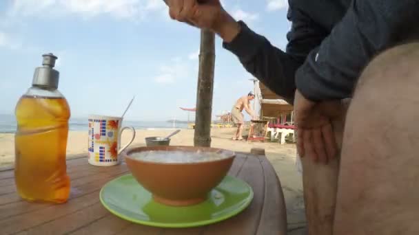 Mężczyzna jedzenie na plaży. — Wideo stockowe