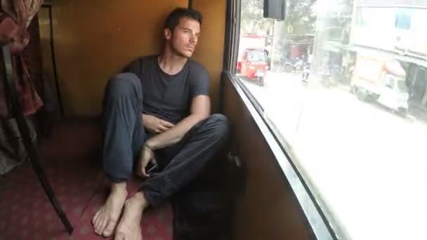 Homme regardant le paysage urbain par la fenêtre du train — Video