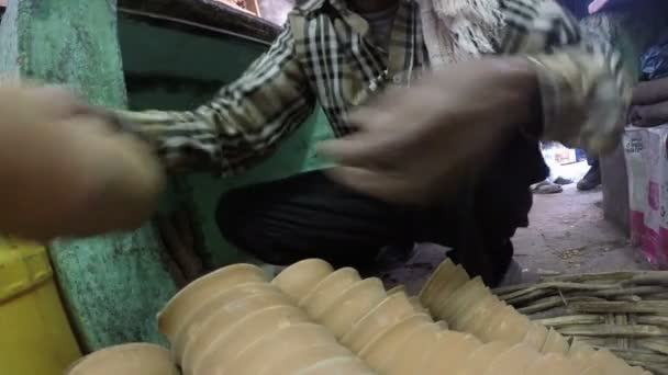 Мужчина расставляет маленькие керамические чашки — стоковое видео