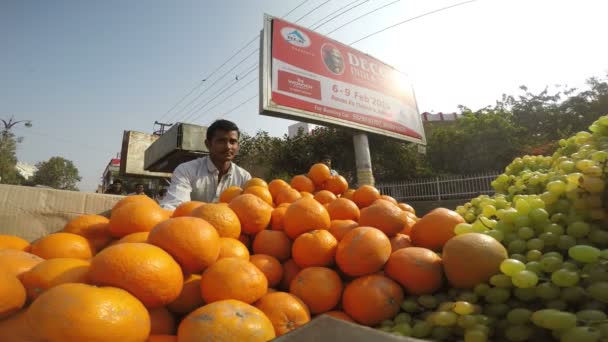 Man vervoer stapel van druiven en sinaasappelen — Stockvideo