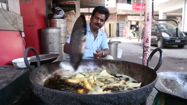 Індійський чоловік посмішки під час приготування їжі samosas. — стокове відео