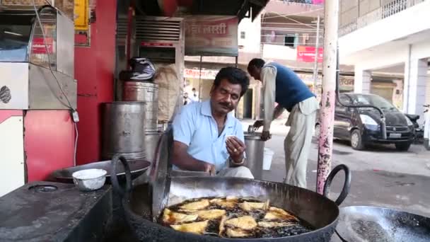 Indian man smiles while cooking samosas. — Stock Video