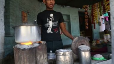 Ateşe kömür ekleyerek adam