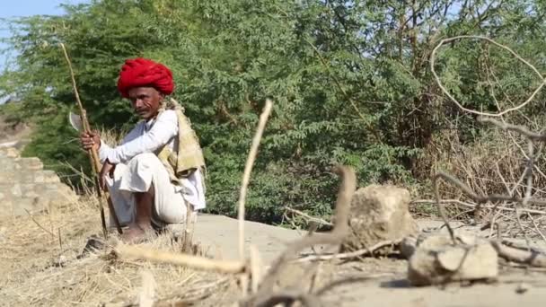 Uomo seduto su una strada del villaggio — Video Stock