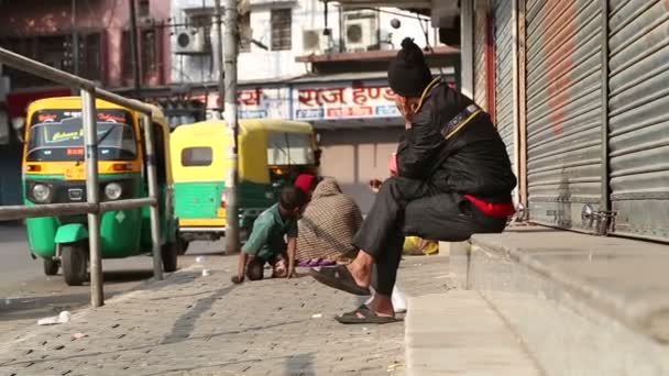 Индиец, сидящий на тротуаре — стоковое видео