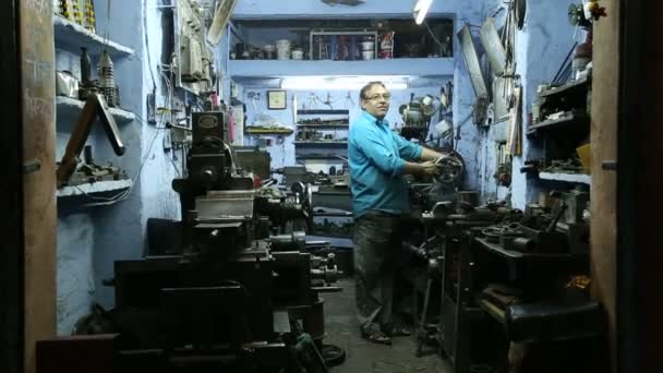 Hombre trabajando en una máquina en el taller — Vídeo de stock