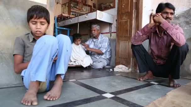 Индийский мужчина стрижет волосы мальчика — стоковое видео