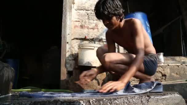 Мальчик стирает белье — стоковое видео