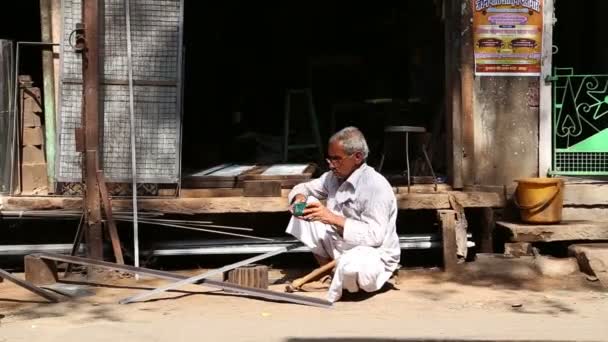Индийский мужчина перед мастерской — стоковое видео