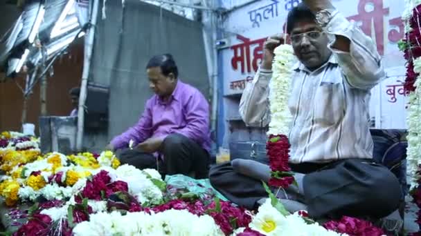 Men piling up colorful flowers — Stock Video