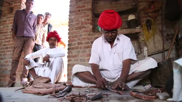 Indian man peeling pliable material — Stock Video