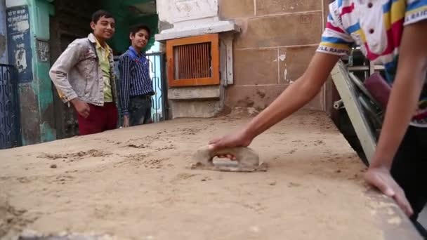 Boys watch their friend realigning sand — Stock Video