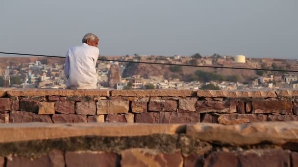 Homme assis sur le mur regardant paysage urbain — Video