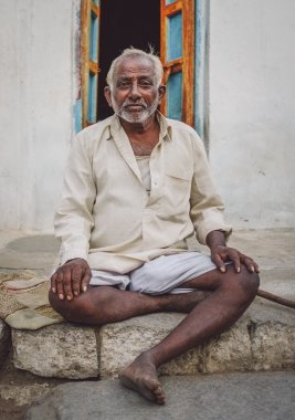 Indian elderly man sits