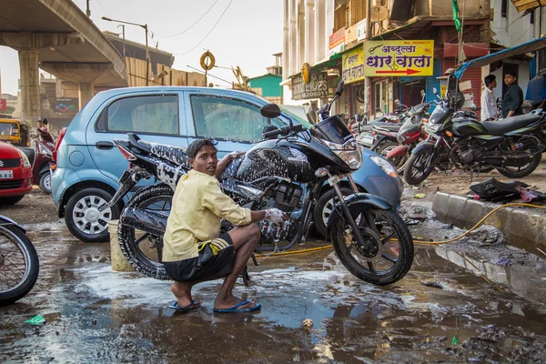 Indyjski chłopiec han myje motocykl — Zdjęcie stockowe