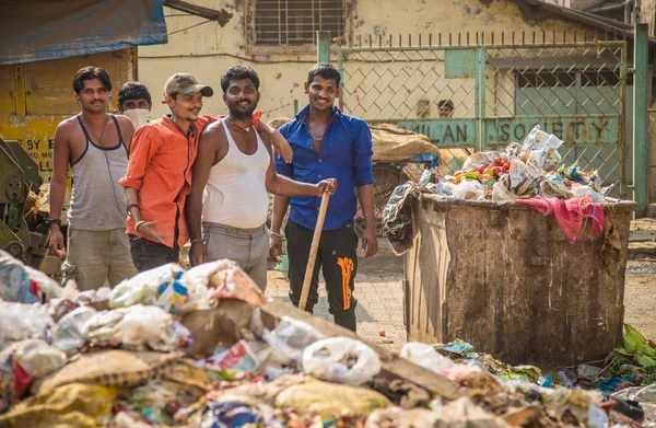 Mannen opstapelen vuilnis op sloppenwijk straat — Stockfoto