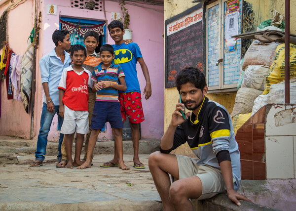 Пять мальчиков стоят вместе на улице в трущобах
