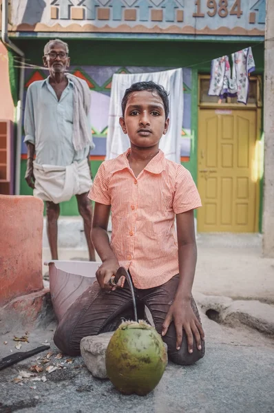 Indian boy opening a coconut — Stock Photo, Image