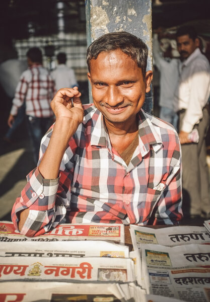 Индиец продаёт газеты.
