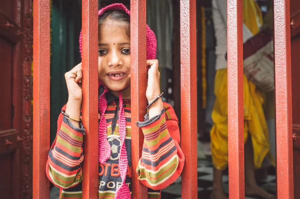 Girl  looks through closed fence — Stockfoto