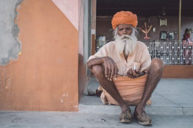 Elderly tribesman sits on ground