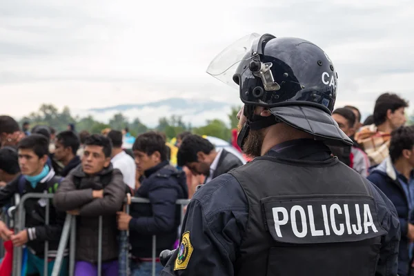 Полицейский перед группой иммигрантов. — стоковое фото