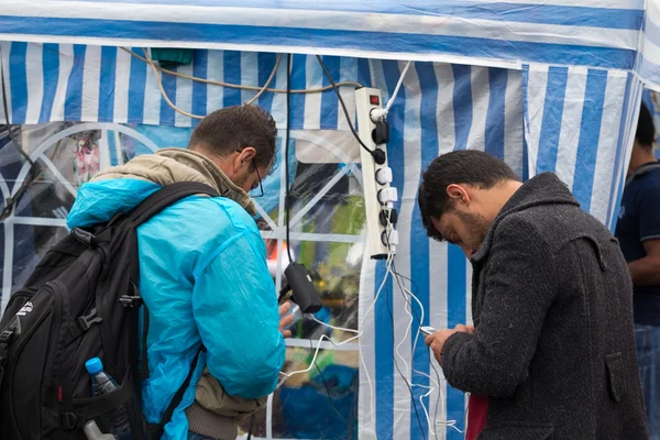 Deux hommes chargent leurs téléphones portables . — Photo