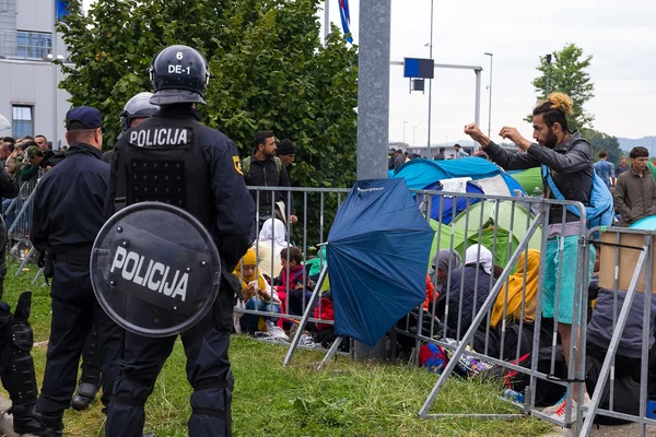 Uomo che parla con la polizia dietro la barriera — Foto Stock