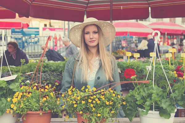 Dívka v slamák pózuje na marketplac — Stock fotografie