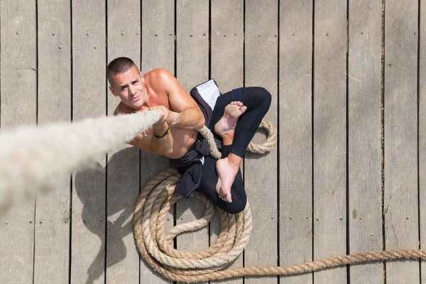 Atleta sem camisa segurando a corda — Fotografia de Stock