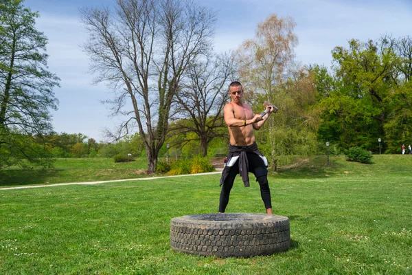 Man träning med slägga och däck — Stockfoto